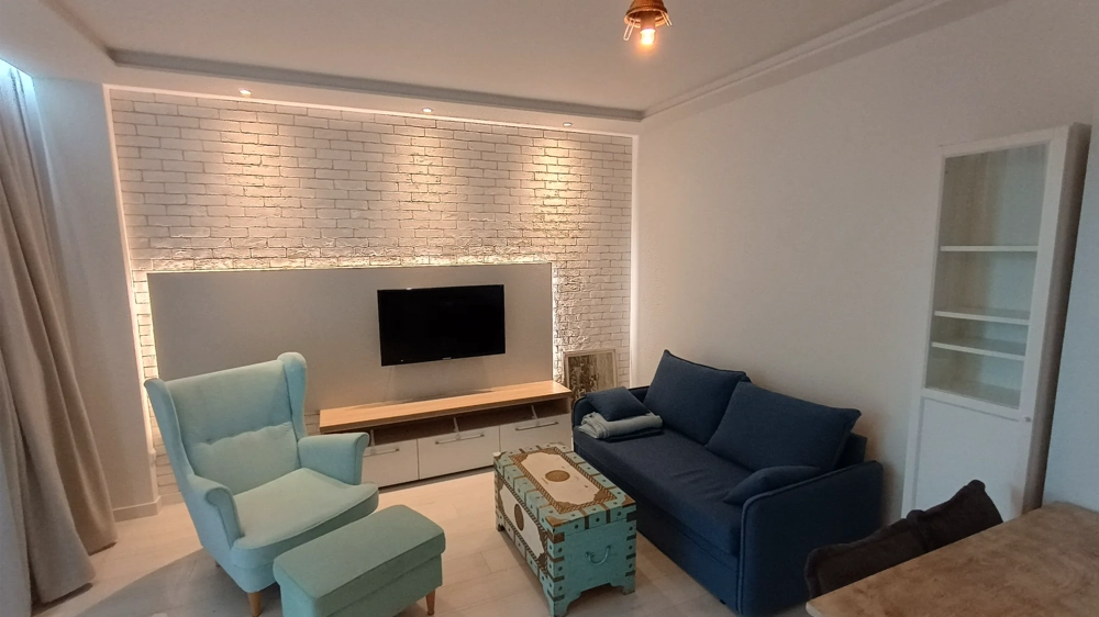 Nowoczesne oświetlenie salonu na tle białej ceglanej ściany z telewizorem i meblami