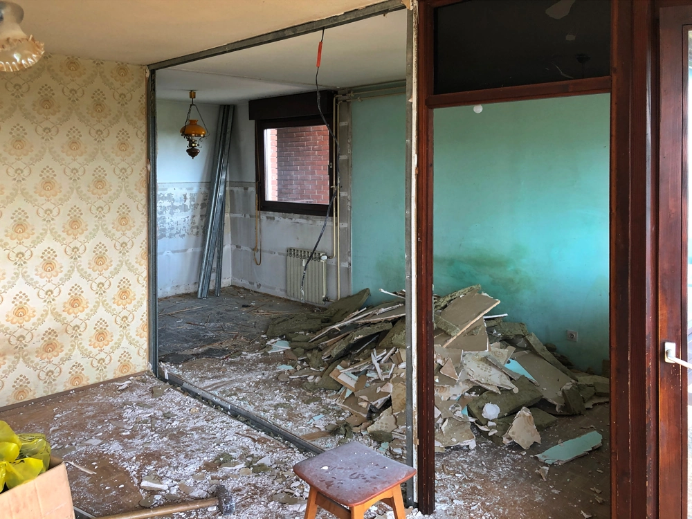 Pozostałości po wyburzeniach: gruz i fragmenty płyt GK na podłodze pomieszczenia przygotowanego do remontu
