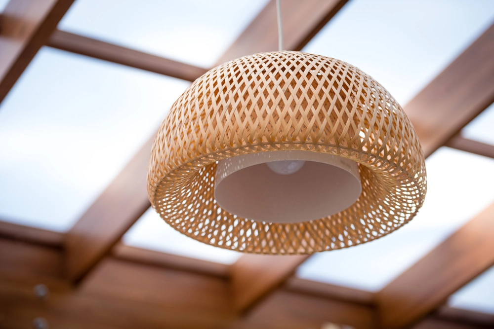 Wisząca lampa pleciona z naturalnego materiału – oświetlenie wnętrza z drewnianym stelażem sufitu