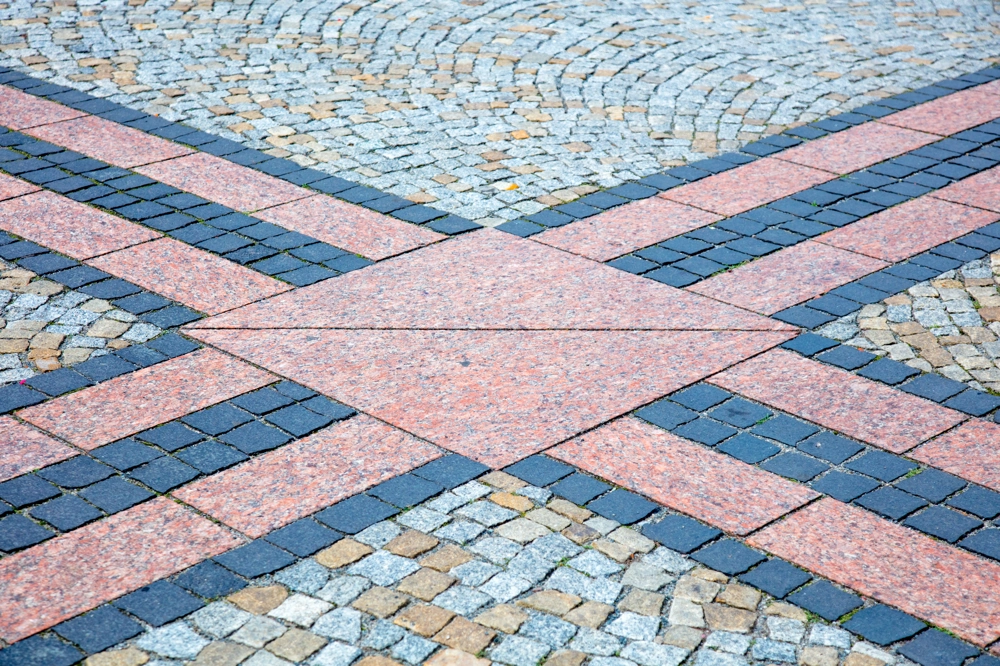 Dekoracyjny wzór z różnokolorowej kostki brukowej ułożonej w geometryczne figury